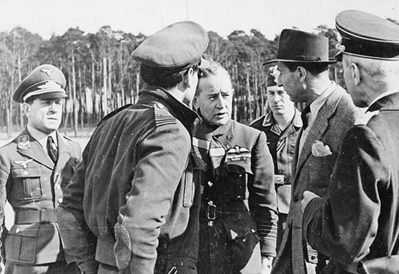 Herr Narville, a member of the Protecting Power, speaks to Group Captain Massey, the senior British officer at Stalag Luft III prison camp.