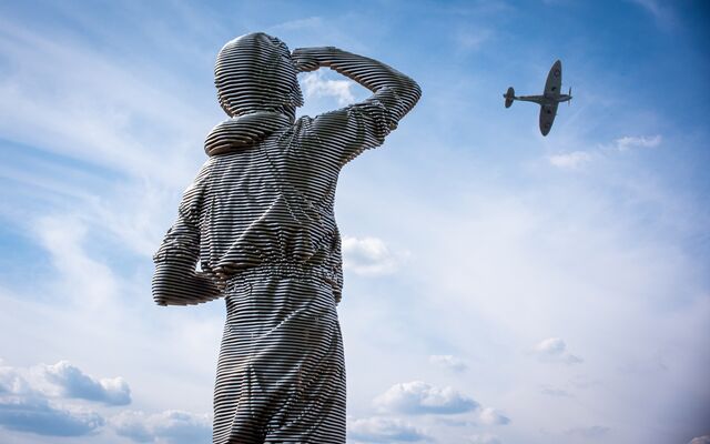 Statue of RAF pilot looking up at Spitfire 