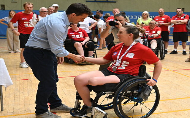 Stacey Mitchell receiving bronze medal shaking hands