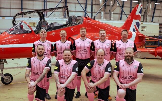 Red Arrows football team in front of Red Arrow