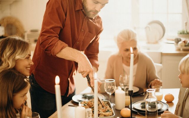 Man serving Christmas dinner at family table