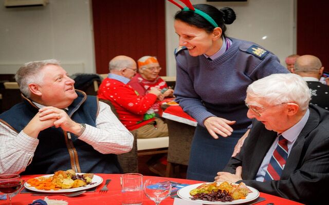 Veterans at dinner table speaking to Brize Norton personnel serving