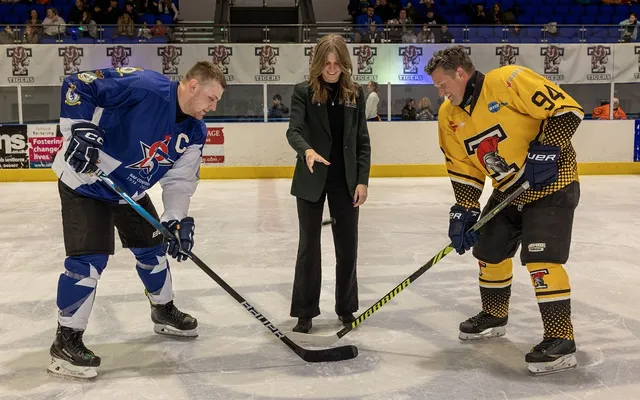 Two players holding sticks ready for the puck drop