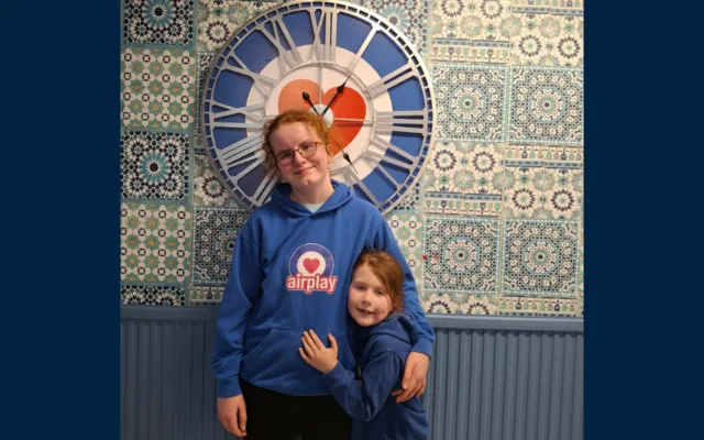 Macey and Isabel in front of Fund clock at Airplay