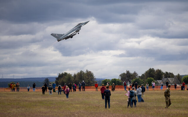 Typhoon plane air display in sky with crowds watching on grass