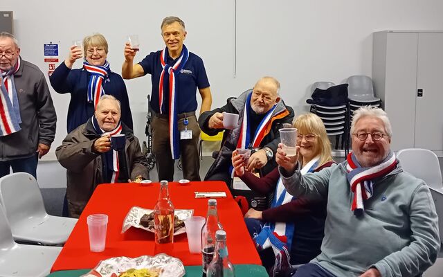 Group of veterans and Sue Powell raising glasses in toast