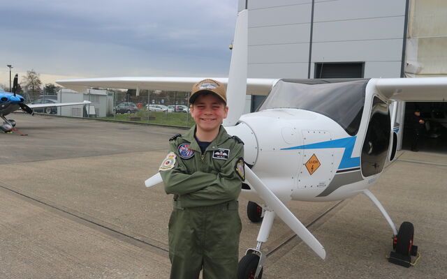Jacob in front of plane wearing flying suit