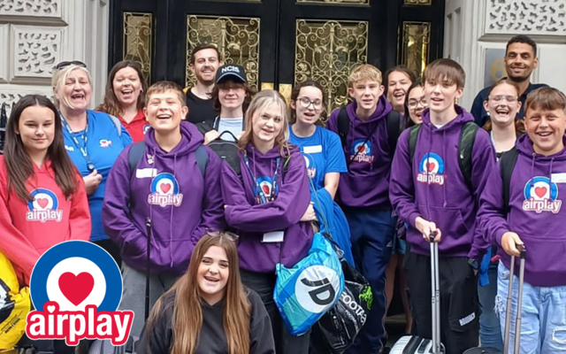 Group of young people in purple and blue Airplay hoodies standing in group posing