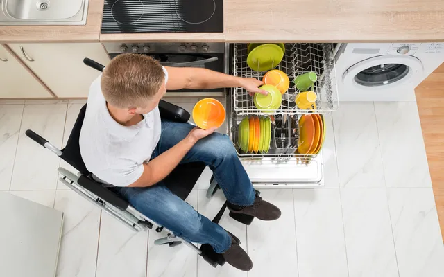 An image of an RAF veteran taking dishes out of his dishawasher