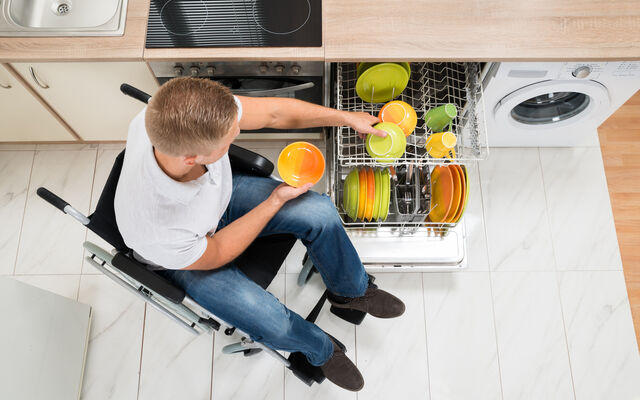 An image of an RAF veteran taking dishes out of his dishawasher