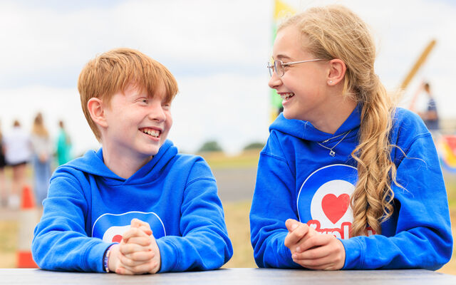 Boy and girl in blue Airplay hoodies smiling at each other