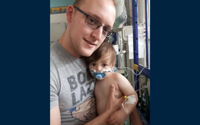 John holding Henry in hospital