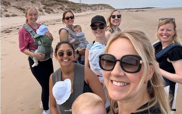 Lossie mums smiling with babies in slings standing on beach