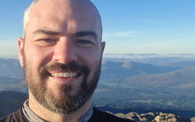 Image of an RAF veteran on a walk with a view of mountains behind him