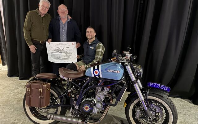 3 men including Stu holding the print in front of motorbike