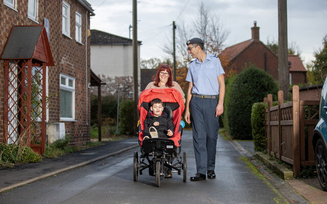 Family walking with son in adapted buggy