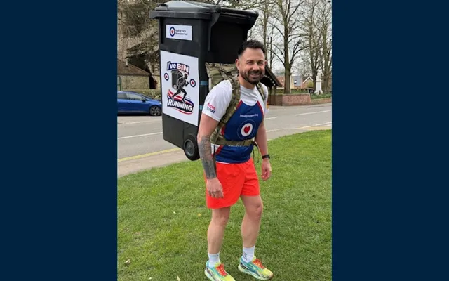 Jaime in Fund vest orange shorts and wheelie bin on back