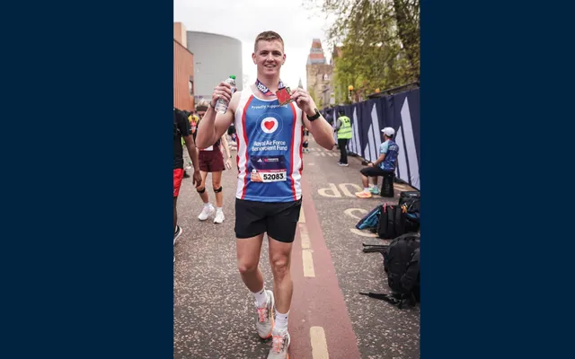 Caylum in Fund vest holding medal up 