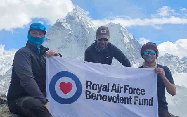 Rowan and two others on Mount Everest climb holding Fund banner
