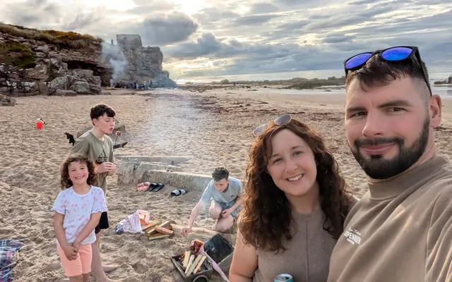 Family on beach with bonfire