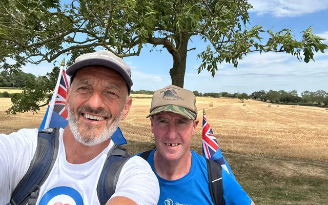 John and Simon smiling in front of field