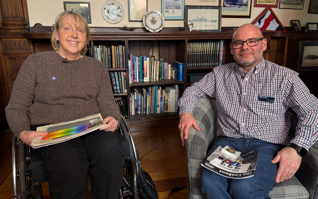 Joanna and John sat side by side smiling