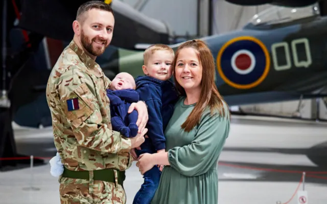 RAF wife Amileigh Salt and her husband, with their two young children, stood in front of a spitfire.