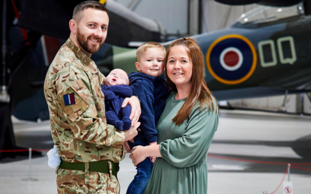 RAF wife Amileigh Salt and her husband, with their two young children, stood in front of a spitfire.