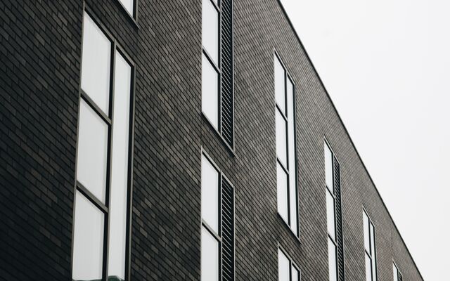 Black and white image of the front of a brick office building.