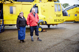 Mick and Lorna McConnell standing in front of an RAF Rescue helicopter