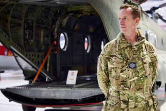 Sam Parsley standing in front of an RAF Chinook