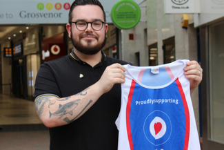 An image of RAF veteran Toby Harris holding a royal air force benevolent fund vest.