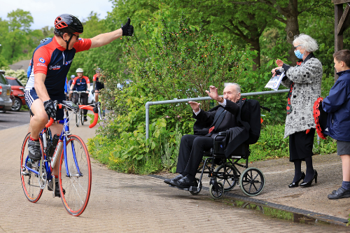 A cyclist gives Johnny Johnson a thumbs up as he passes by