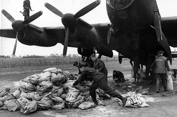 Operation Manna – Airmen of 514 Squadron, load sacks of urgently needed food and supplies on to one of the squadron. MOD/Crown Copyright.