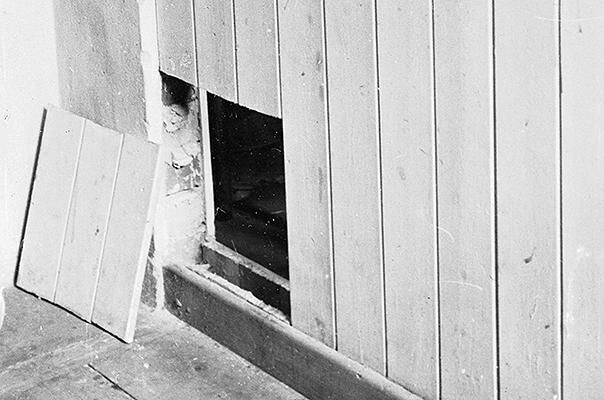 A photograph showing a hole made in the bottom of a door by a prisoner of war, in order to escape from solitary confinement at Stalag Luft III.