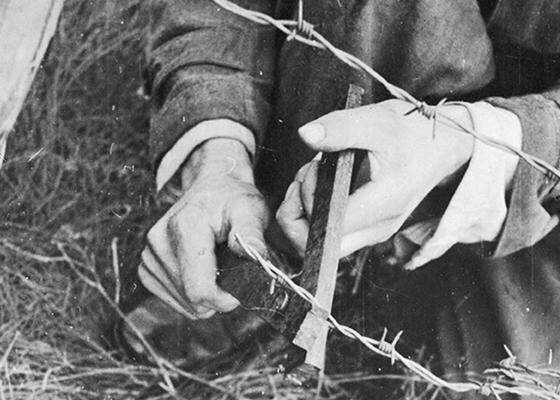 A pair of wire cutters made by Prisoners of War at Stalag Luft III are demonstrated for the camera.