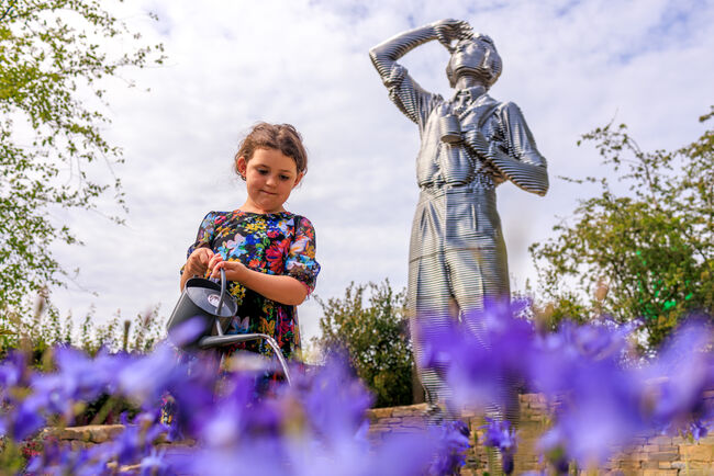 A young child watering the garden