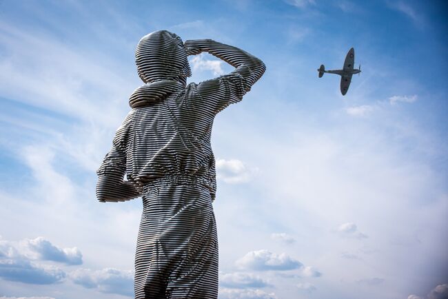 Statue of RAF pilot looking up at Spitfire 