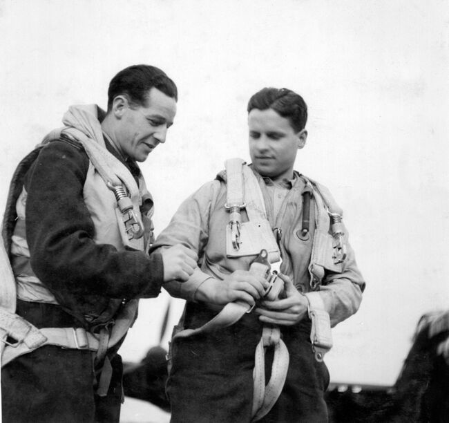 The Commanding officer of 617 Squadron, Wing Commander Guy Gibson, is assisted into his parachute harness by his rear gunner, Flight Lieutenant RAD Trevor-Roper, before leading his Squadron on the famous 'Dambusters' Raid (Operation CHASTISE) from Scampton, Lincolnshire, during the night of 16/17 May 1943. Crown Copyright, MOD.