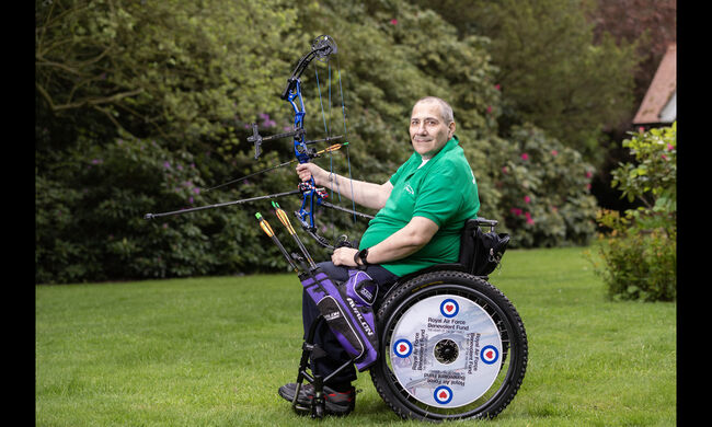 Mick Curran in sports wheelchair with bow and arrow