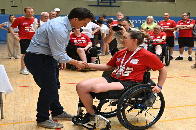 Stacey Mitchell receiving bronze medal shaking hands