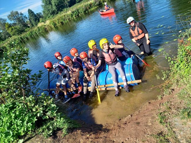 Children on rafts going into lake