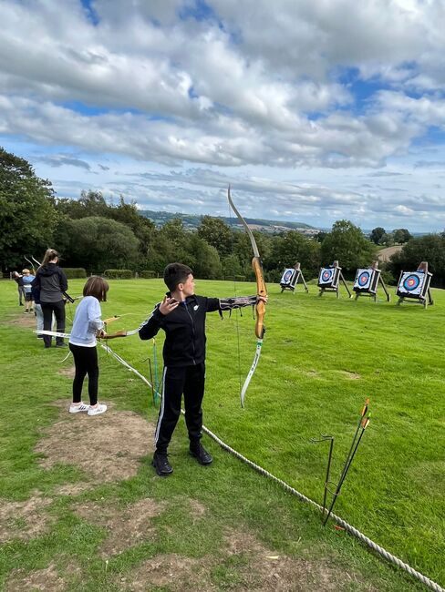 Children doing archery in a field