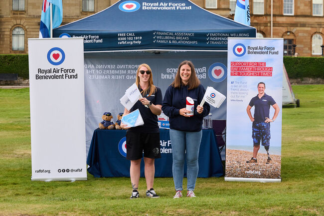 Community Engagement team at Fund welfare stand smiling holding merch