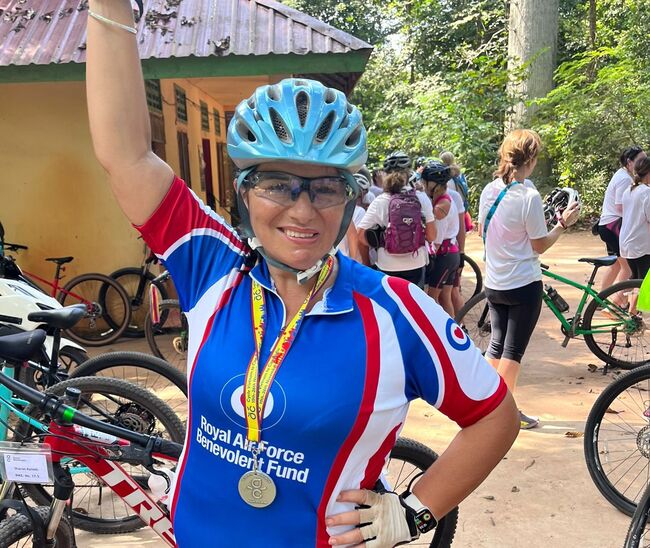 Trish wearing Fund branded shirt, helmet and medal