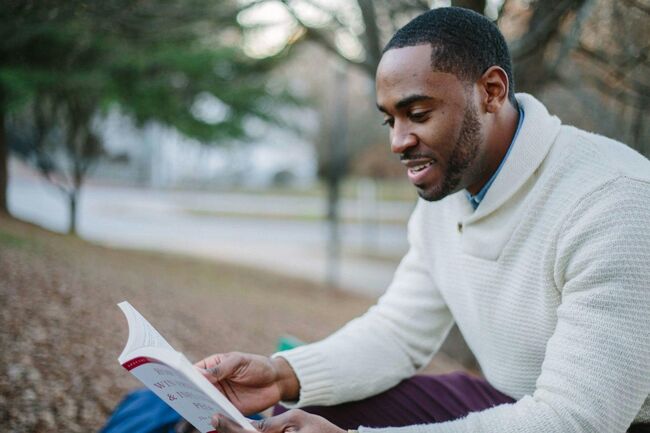 Man reading book outside in nature