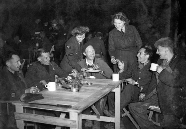 WAAFs serving refreshments to a group of recently repatriated prisoners of war in the reception hangar at Wing, Buckinghamshire, on 17 April 1945.