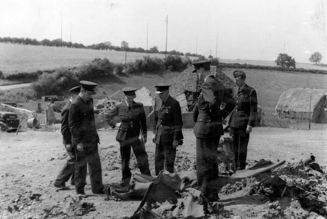 Marshal of the Royal Air Force Charles Portal, Chief of the Air Staff, inspects the scene where a flying bomb was brought down in Southern England during a tour of balloon defences on 24 June 1944. He is accompanied by Air Vice Marshal WCC Gell (Air Officer Commanding-in-Chief Balloon Command), Air Commodore PL Lincoln and Group Captain JP Hitchings.
