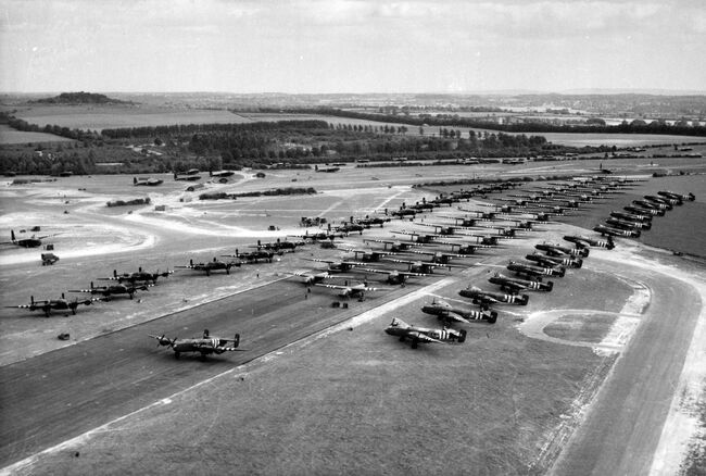 Operation MALLARD: Aircraft prepared for the reinforcement of the British airborne assault, assembled at Tarrant Rushton, Hampshire, on the afternoon of 6 June 1944. On the runway are General Aircraft Hamilcar heavy-lift gliders, preceded by two Airspeed Horsa troop-carrying gliders, while parked on each side of them are Handley Page Halifax glider-tugs of Nos 298 and 644 Squadrons.