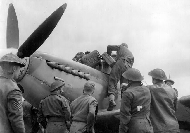 Servcing commandos refuel and re-arm one of the first Supermarine Spitfires to land in France, a Mark IX of 441 Squadron RCAF, at the advanced landing ground at B3/Sainte Croix-sur-Mer, Normandy, on the afternoon of 10 June 1944.